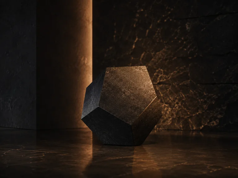 Faceted dark stone sculpture illuminated by warm architectural light.